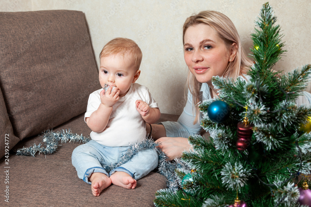 happy mother and her little daughter decorate the Christmas tree happy mother and her little daughter decorate the Christmas tree