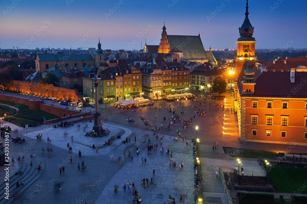 Warsaw, Poland - August 11, 2017: Beautiful aerial night panoramic view of Plac Zamkowy square in Warsaw, with historic building, including Sigismund III Vasa Column, and people at warm summer night W