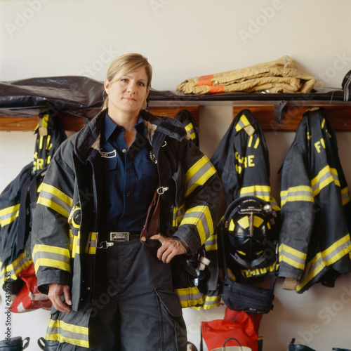 Portrait of female firefighter standing in fire station
