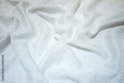 In selective focus a white wrinkled bedsheet on the bedroom for background texture 