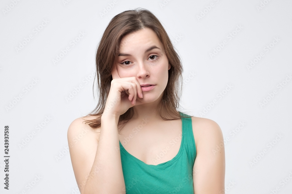 Pissed woman leaning on fist and gazing with careless expression Pissed woman leaning on fist and gazing with careless expression
