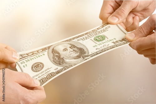 Hands holding one hundred dollars banknote over background