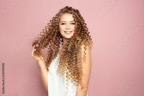 Portrait of beautiful young woman with shiny wavy hair on color background