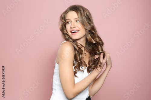 Obraz na plátne Portrait of beautiful young woman with shiny wavy hair on color background