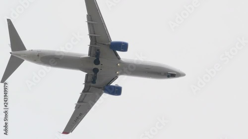 The Commercial passenger airplane flying overhead on sunny day. photo