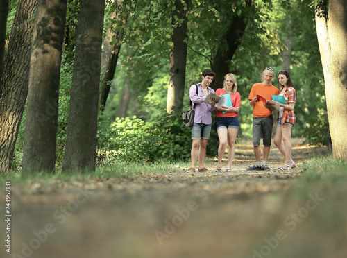 group of happy young students walking outdoors. Looking aside