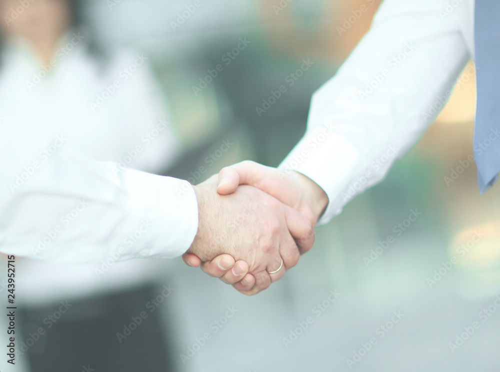 business handshake of employees on the background of the office.
