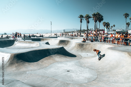 June 10, 2018. Los Angeles, USA. Venice beach skate park by the ocean. People skating at the skatepark showing different tricks.  photo