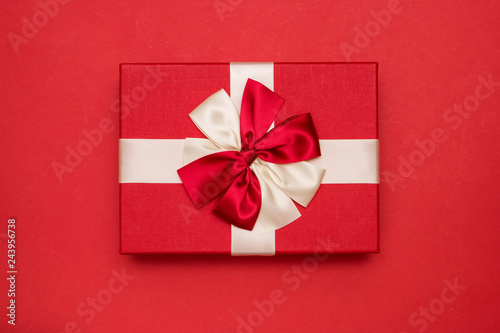 Real box with white and red bow and ribbon top view on Valentine's day isolated on red background. Flat lay. Copy space