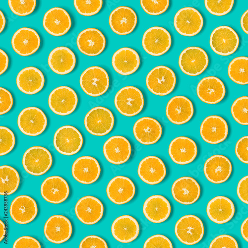 Fruit pattern of orange slices on blue background. Flat lay, top view. Food background.