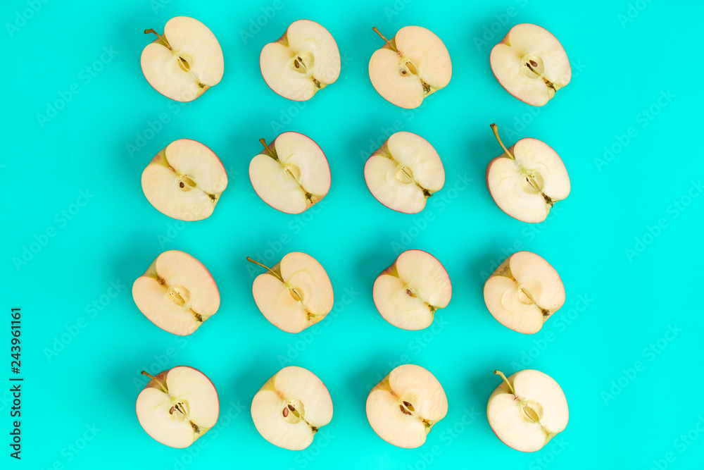 Fruit pattern on blue background. Apple halves geometrical layout. Flat lay, top view. Food background. Fruit pattern on blue background. Apple halves geometrical layout. Flat lay, top view. Food background.