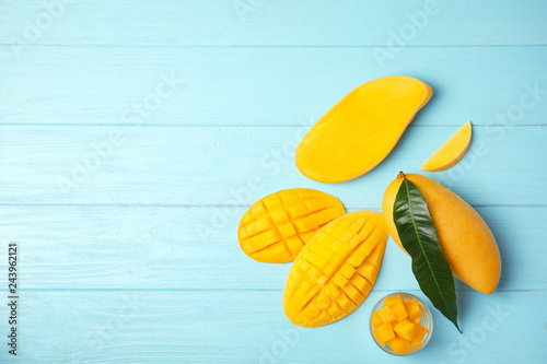 Flat lay composition with mango on wooden background. Space for text