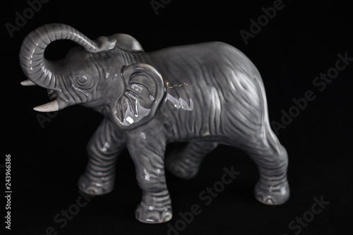 gray porcelain elephant on a black background © Laurenx