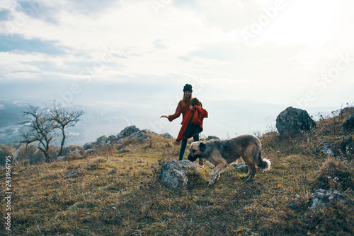woman walking with dog in the mountains nature