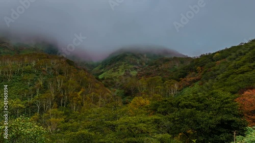 Timelapse of Fog Revealing Fall Colored Mountain Summit -Zoom Out- photo