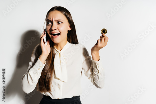 young business woman holding a golden beatcoin, emotionally talking on the phone photo