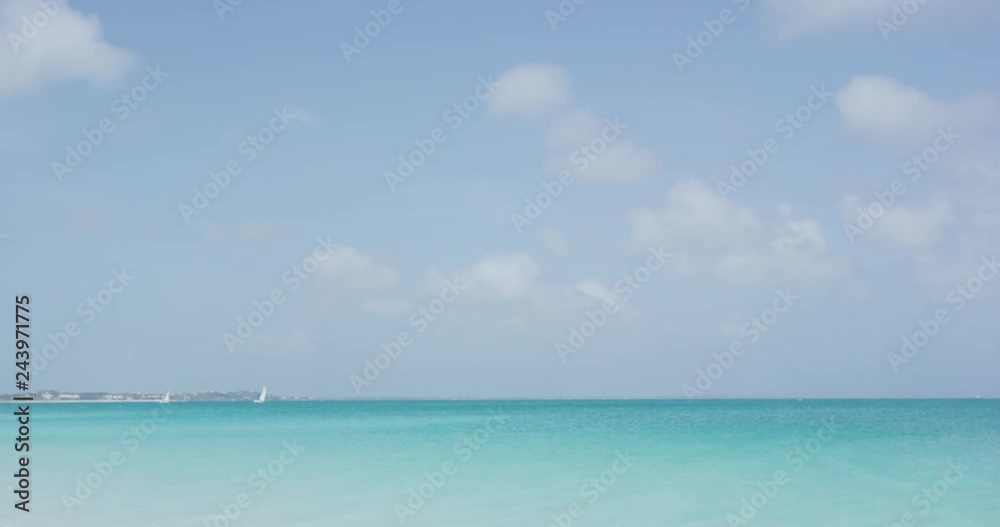 Elegant sexy woman in white bikini walking at beach. Young female is on summer vacation wearing swimwear on sunny day against blue sky in paradise. Elegant sexy woman in white bikini walking at beach. Young female is on summer vacation wearing swimwear on sunny day against blue sky in paradise.