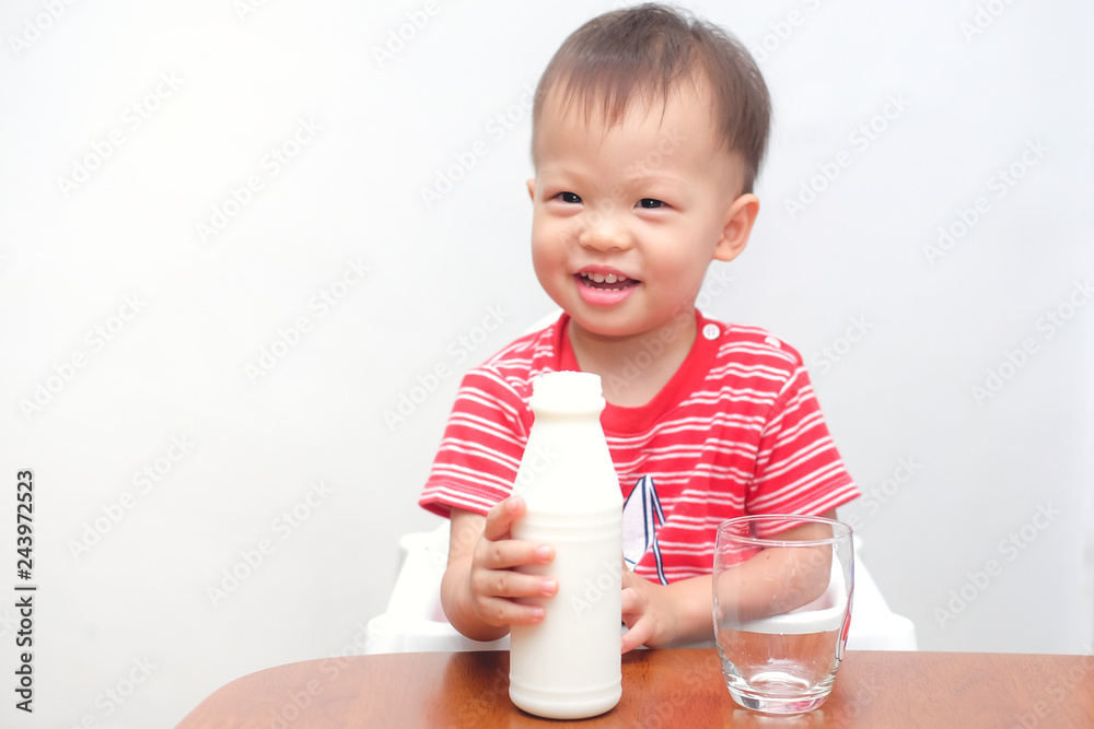 Cute smiling Asian 2 years old toddler baby boy child prepare to drinking milk from a glass