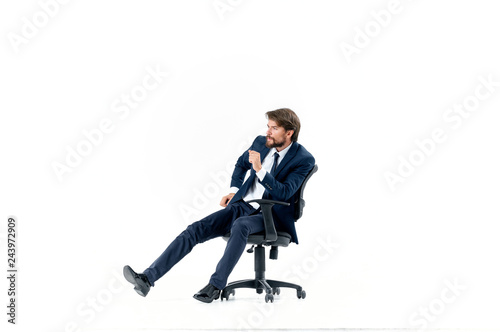 man in a suit sitting on a chair on an isolated background