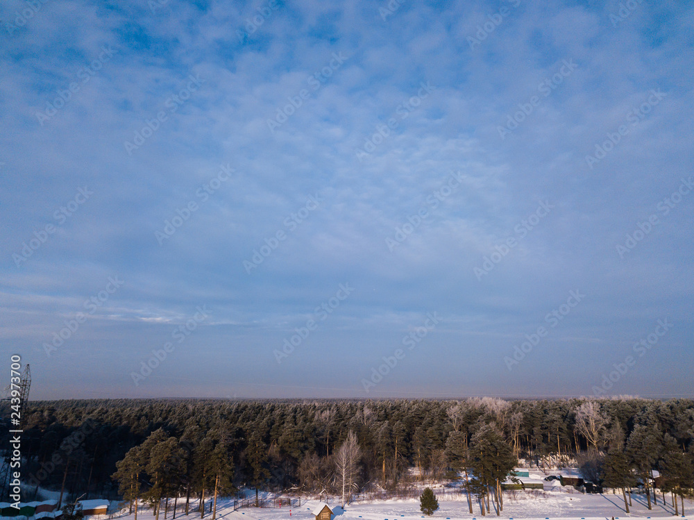 Helicopter drone shot. Aerial photography of green forest with road, house in cold winter day.