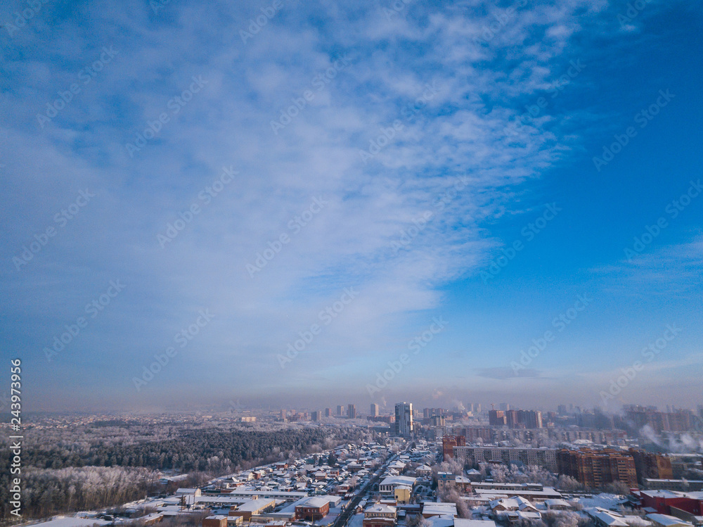 Aerial photography of a modern city: high-rise buildings, a big road, shops and parks on a cold winter day with a blue sky.Helicopter drone shot Aerial photography of a modern city: high-rise buildings, a big road, shops and parks on a cold winter day with a blue sky.Helicopter drone shot