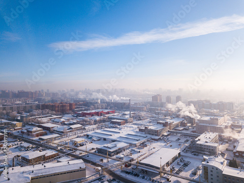 Aerial photography of a modern city  high-rise buildings  a big road  shops and parks on a cold  winter day with a blue sky.Helicopter drone shot