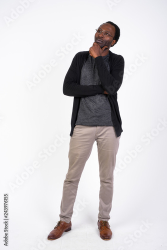 Full body shot of handsome African man thinking and looking up