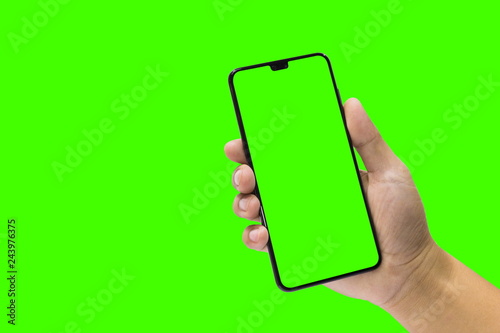 Man holding a black mobile phone and green screen isolated on a green background.