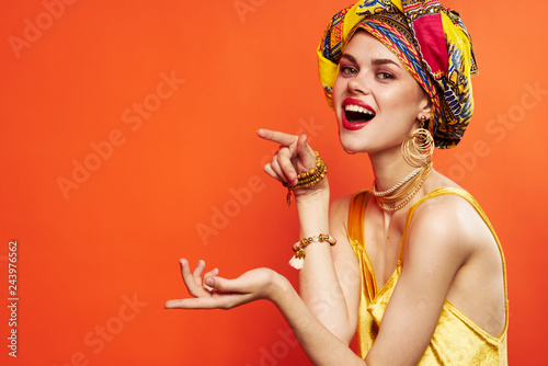 joyful woman in a headdress holds her hands free place