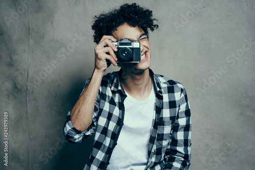African man with curls takes pictures on retro camera