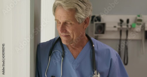 Close up portrait of senior medical professional turning to look into camera