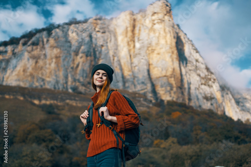 traveler woman in a sweater hat with a backpack in the mountains tript autumn nature
