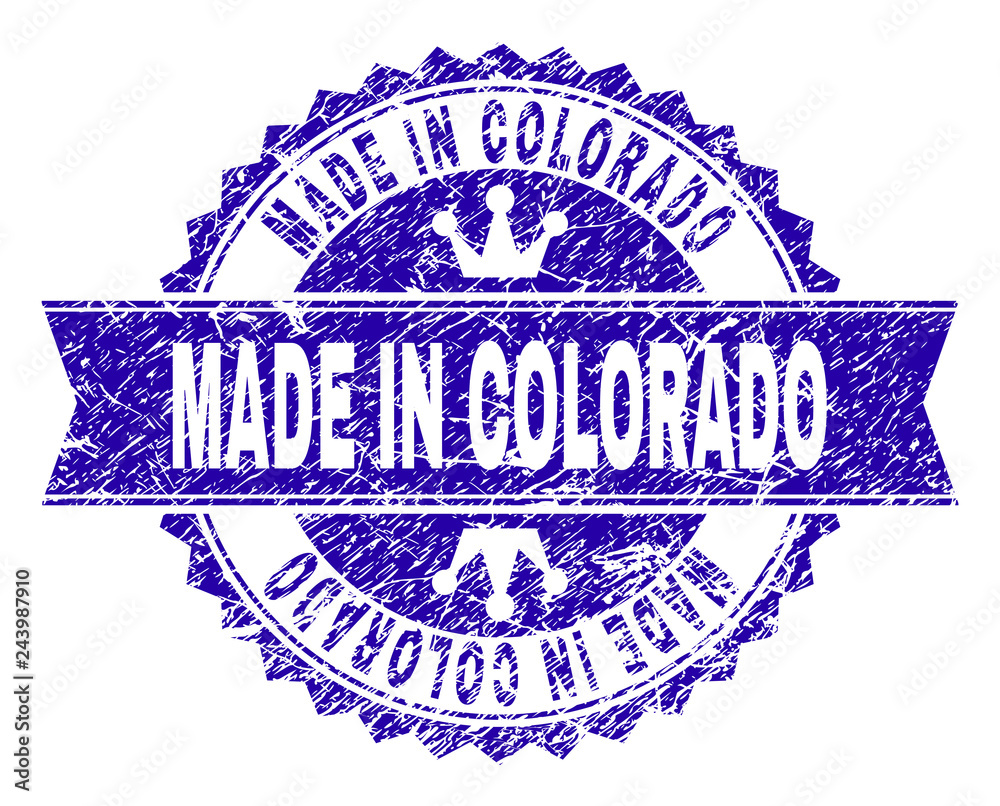 Obraz premium MADE IN COLORADO rosette stamp seal watermark with grunge style. Designed with round rosette, ribbon and small crowns. Blue vector rubber watermark of MADE IN COLORADO title with grunge style.