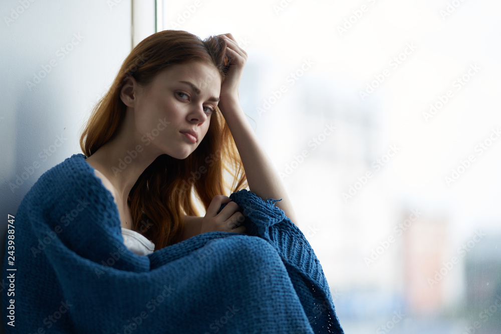 sad woman sitting by the window depression autumn