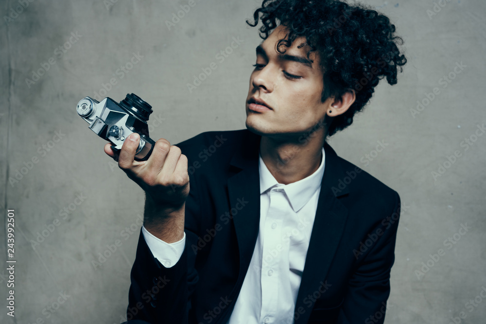 african curly man looking at old retro camera african curly man looking at old retro camera