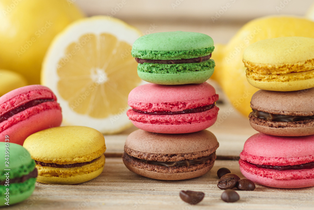 Green, pink, yellow and brown french macarons with lemon and coffee beans