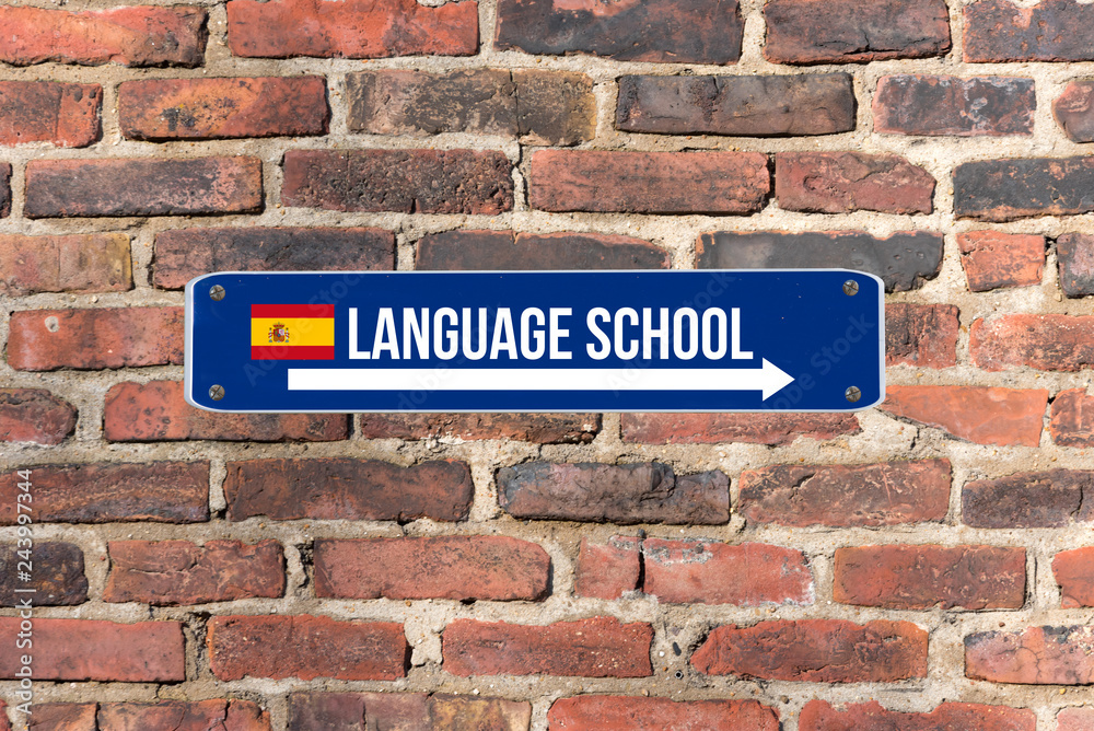 Fototapeta premium Ein Schild an der Wand weist auf die Sprachschule für spanische Sprache hin