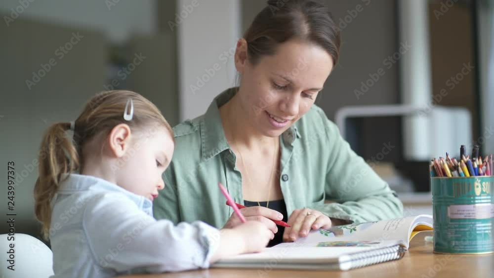 Mother teaching adorable young daughter how to draw and write at home Mother teaching adorable young daughter how to draw and write at home