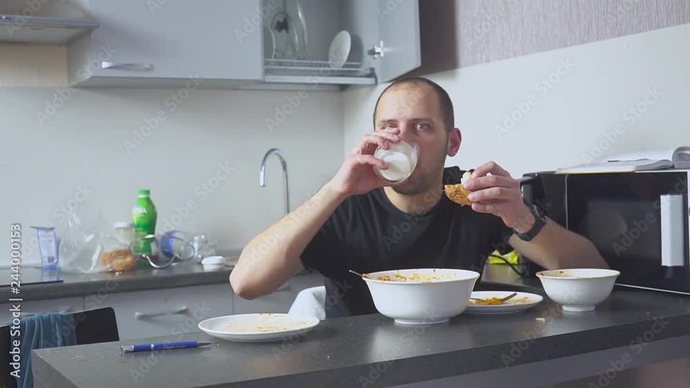 Sad man eating pasta at the table. Home in his kitchen. He worries because of his problems. Sad man eating pasta at the table. Home in his kitchen. He worries because of his problems.