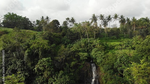aerial drone photo of amazing view of waterfall in the jungle of Bali island. Sunset time in the rainforest.