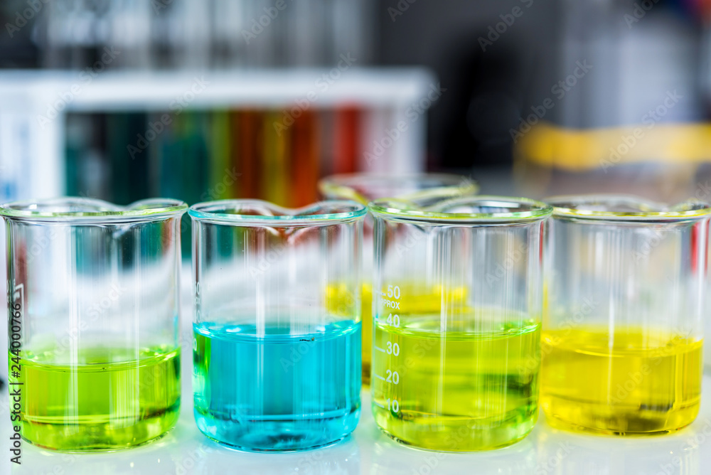 Lab glassware containing chemical liquid with laboratory background, science research and development concept Lab glassware containing chemical liquid with laboratory background, science research and development concept