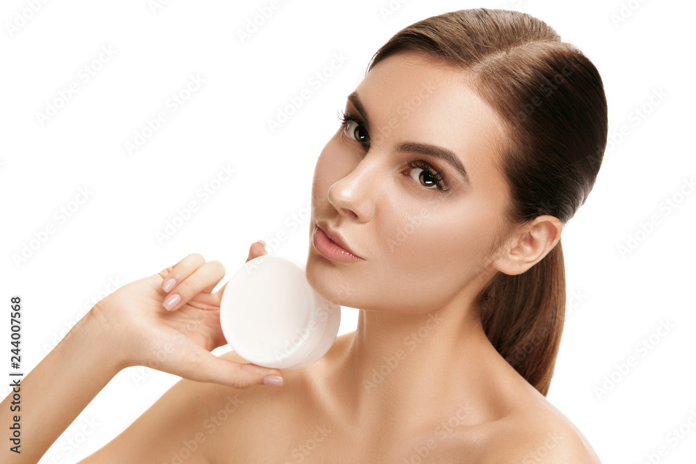 Cute girl preparing to start her day. She is applying moisturizer cream on face at studio. The beauty, care, skin, treatment, health, spa, cosmetic and advertising concept Cute girl preparing to start her day. She is applying moisturizer cream on face at studio. The beauty, care, skin, treatment, health, spa, cosmetic and advertising concept