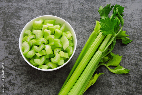 Chopped fresh celery stalks in a bowl. Top view.