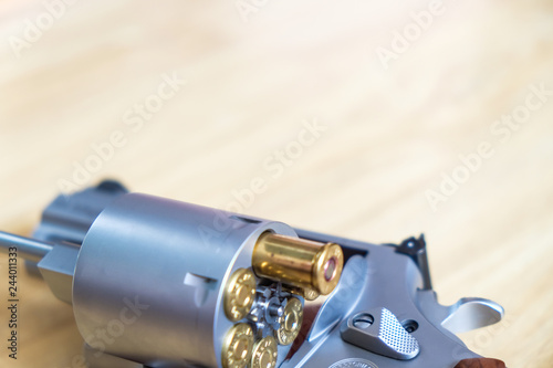 .357 .44 magnum revolver gun with bullet on wood background photo