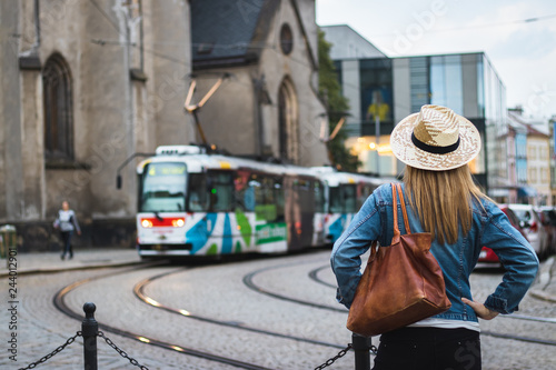Woman tourist is looking at passing tram in ancient city Olomouc, Czech Republic, Europe