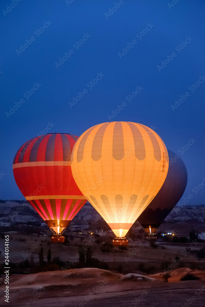 Fototapeta premium Beautiful hot air balloons flying over Cappadocia landscape at sunrise