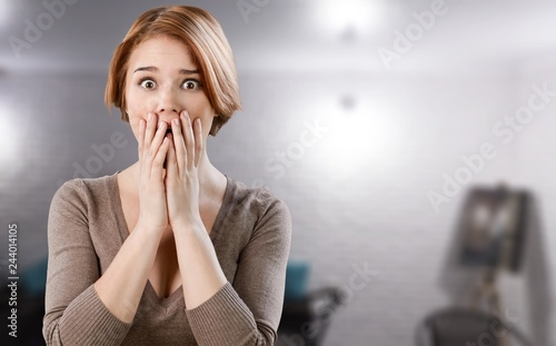 Worried woman holding face with hands on background
