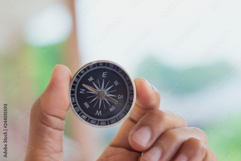 holding compass on blurred background. Using wallpaper or background travel or navigator image. holding compass on blurred background. Using wallpaper or background travel or navigator image.