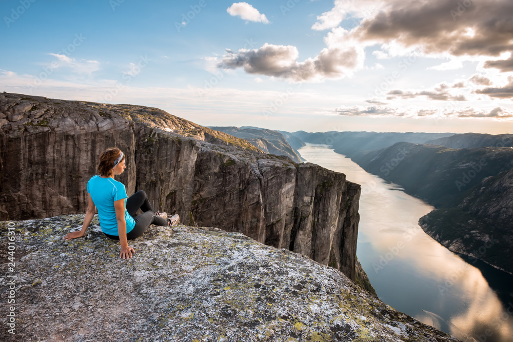 Sporty woman on the top of fjord near Kjeragbolten, Norway. Relax, success, motivation concept