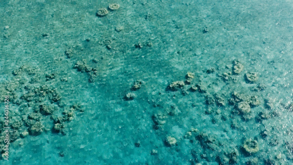 stunning aerial drone image of a a small fishing boat entering an a sea ocean anchorage in a channel next to a coral reef in crystal clear azure blue water at a remote isolated tropical island stunning aerial drone image of a a small fishing boat entering an a sea ocean anchorage in a channel next to a coral reef in crystal clear azure blue water at a remote isolated tropical island